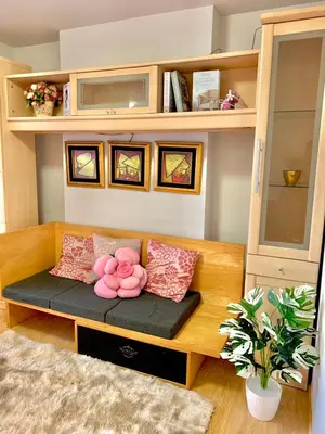 a teddy bear sitting on a bench in a room at เช่ารายเดือน DCon Rattanathibet in Ban Sai Ma