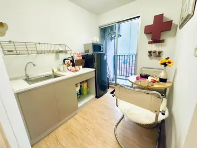 a small kitchen with a sink and a cross on the wall at เช่ารายเดือน DCon Rattanathibet in Ban Sai Ma