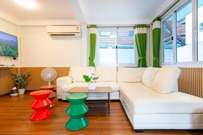 a living room with a white couch and green curtains at Friend House BKK in Bangkok