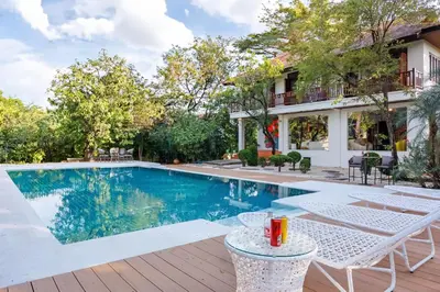 a swimming pool with tables and chairs next to a house at \u66fc\u8c372000\u5e73\u65b9\u7c73\u5e84\u56ed\u522b\u5885 \u8d85\u5927\u6cf3\u6c60sukhmvit\u4f4d\u7f6e\u7edd\u4f73 9\u95f4\u5367\u5ba4 in Amphoe Phra Khanong