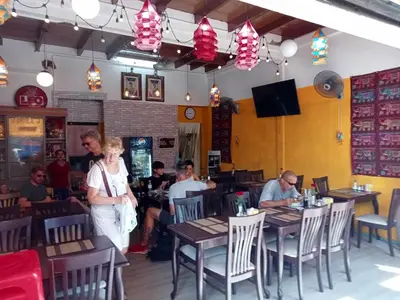 a group of people sitting at tables in a restaurant at Bang lumphu house&bistro in Bangkok