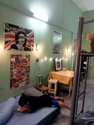a person laying on a bed in a room at Bang lumphu house&bistro in Bangkok
