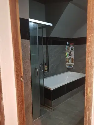 a bathroom with a shower and a bath tub at BTL Sunny in Bang O
