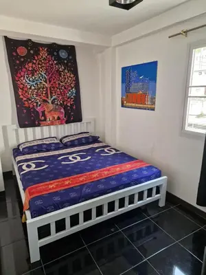 a bedroom with a bed with a painting on the wall at BTL Sunny in Bang O