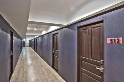 a hallway with blue walls and brown doors and a sign at Chateau de Sukhumvit in Bangkok