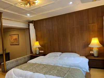 a bedroom with two beds and two lamps at Quinstel Guesthouse in Bangkok