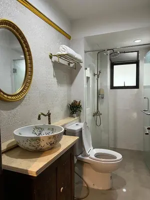a bathroom with a sink and a toilet and a mirror at Quinstel Guesthouse in Bangkok