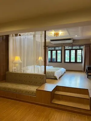 a large bedroom with two beds and a large window at Quinstel Guesthouse in Bangkok