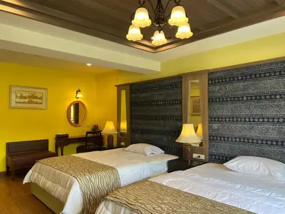 a hotel room with two beds and a chandelier at Quinstel Guesthouse in Bangkok