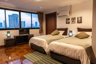 a bedroom with two beds and a large window at Rooftop Paradise & Koi Pond-6BR Hideaway@Icon Siam in Bangkok