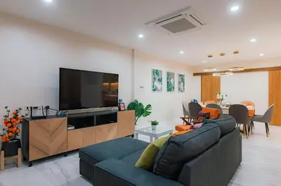 a living room with a couch and a flat screen tv at PRIME SUKHUMVIT MODERN HOME, Phrom Phong BTS, Em District, Up to 14 guests in Bangkok