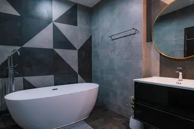 a bathroom with a tub and a sink and a mirror at PRIME SUKHUMVIT MODERN HOME, Phrom Phong BTS, Em District, Up to 14 guests in Bangkok