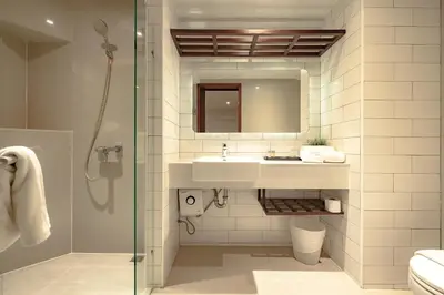 a bathroom with a sink and a shower at Coco Hotel in Bangkok