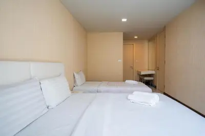 a bedroom with two beds with white sheets at LIV@5 Condominium in Makkasan