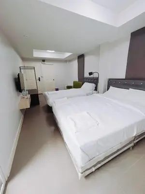 a room with three beds and a tv in it at Mitr Inn Mrt Samyot Station - The Grand Palace in Bangkok