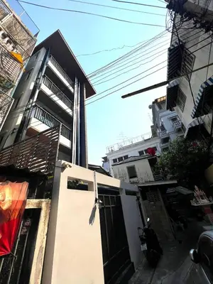 a house with a door in front of a building at Mitr Inn Mrt Samyot Station - The Grand Palace in Bangkok