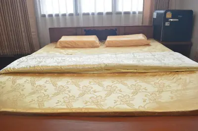 a bed with two pillows on top of it at Sweety Secret Guesthouse in Ban Tambon Bang Khae