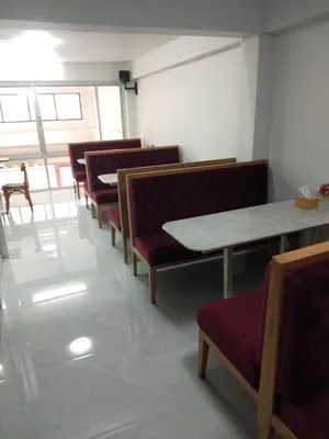 a row of chairs and tables in a room at Sweety Secret Guesthouse in Ban Tambon Bang Khae