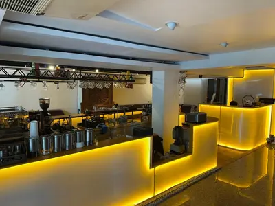 a kitchen with yellow lighting in a restaurant at Longzhu Guesthouse in Bangkok