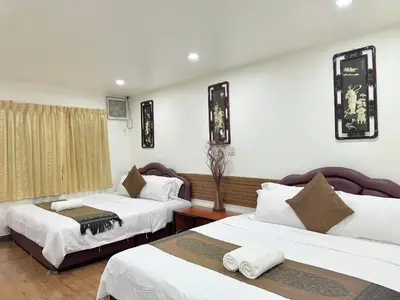 a hotel room with two beds with white sheets at Longzhu Guesthouse in Bangkok