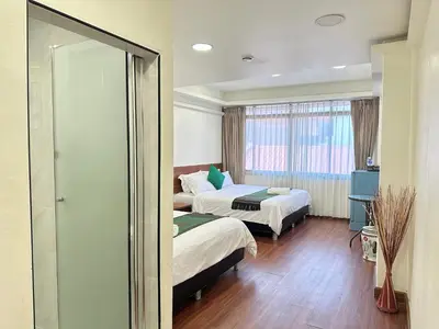 a hotel room with two beds and a mirror at Longzhu Guesthouse in Bangkok