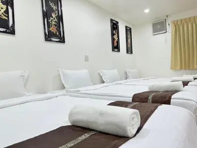 a group of white beds in a room at Longzhu Guesthouse in Bangkok