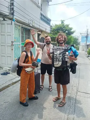 a group of three people standing on a street at Caravan Hotel have TV & Netflix in Bangkok