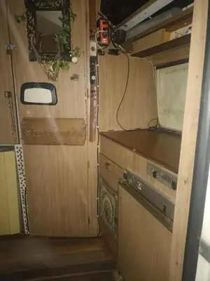 an interior view of an rv with a kitchen and a door at Caravan Hotel have TV & Netflix in Bangkok
