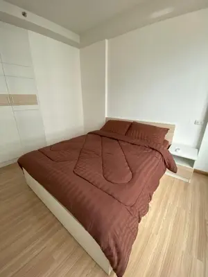 a bedroom with a large bed in a white room at 1BR Apartment in Bangkok