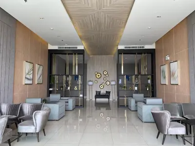a lobby with couches and chairs in a building at 1BR Apartment in Bangkok
