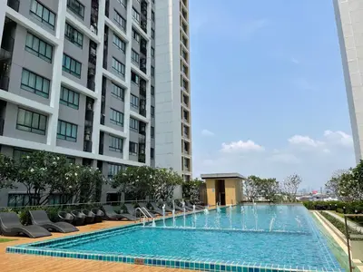 a swimming pool in front of a tall building at 2BR Apartment in Bangkok