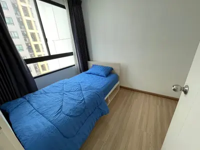 a small bedroom with a blue bed and a window at 2BR Apartment in Bangkok