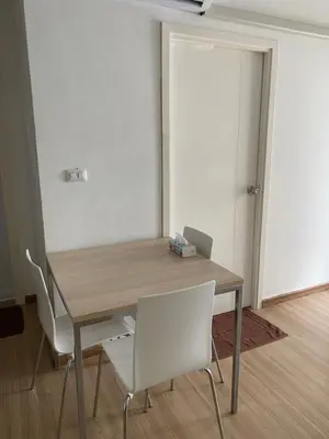 a wooden table with two white chairs and a door at 2BR Apartment in Bangkok