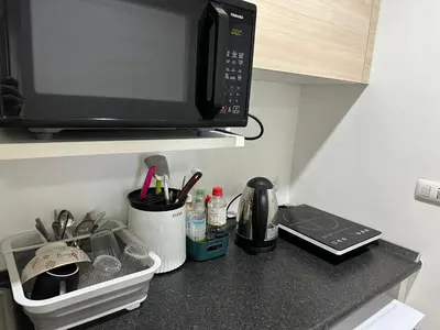 a kitchen counter with a microwave and a sink at 2BR Apartment in Bangkok