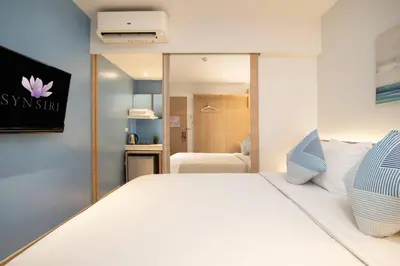 a bedroom with a white bed with a sign on the wall at สินสิริ นวมินทร์96 in Ban Baen Phichit