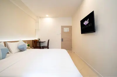 a bedroom with a white bed with a pink flower on the wall at สินสิริ นวมินทร์96 in Ban Baen Phichit
