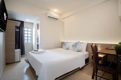 a bedroom with a white bed and a desk at สินสิริ นวมินทร์96 in Ban Baen Phichit