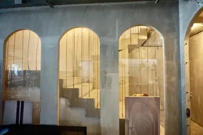 a room with three arched doors and a staircase at Hip and funky apartment silom Soi 3, with rooftop view in Bangkok