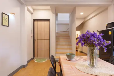 a dining room with a table with purple flowers in a vase at t-t-haus in Bangkok
