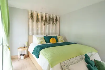 a bedroom with a green and white bed with a window at t-t-haus in Bangkok