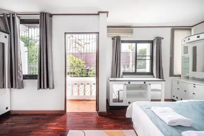a white bedroom with a bed and windows at MIQ HK16 - 3BR Huai Khwang MRT with Pool Table near Jodd Fair in Ban Zong Katiam