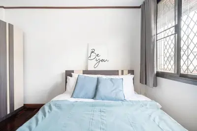a bedroom with a bed with blue sheets and a window at MIQ HK16 - 3BR Huai Khwang MRT with Pool Table near Jodd Fair in Ban Zong Katiam