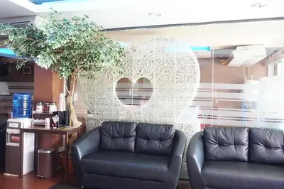 a waiting room with two chairs and a heart wall at Bangkok Travel Suites Hotel in Nonthaburi