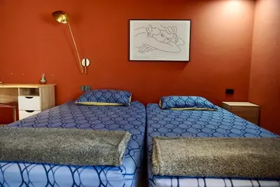 a bedroom with a bed and a picture on the wall at Silom Soi 3 Hash Apartment hip and funky with rooftop view in Bangkok