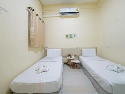 two beds in a hospital room with a heater at EZ Sleep @ Ratchada 19 in Bangkok