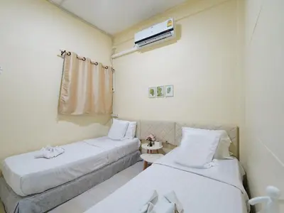 a hotel room with two beds and a window at EZ Sleep @ Ratchada 19 in Bangkok