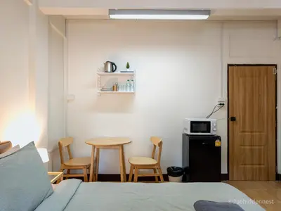 a bedroom with a bed and a table and chairs at 206HiddenNest, Local Room with Street Food only 15 min walk to Skytrain in Bangkok