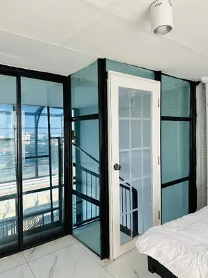 a bedroom with glass doors and a view of a balcony at Chubby 9 in Bang O