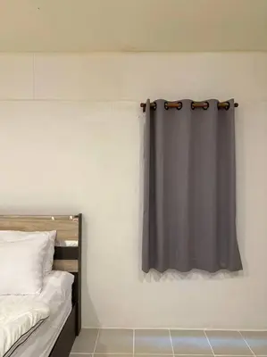 a bedroom with a black curtain on the wall at Chubby 5 Room 5 in Bangkok