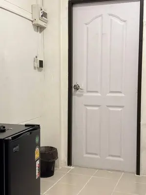 a white door in a room with a refrigerator at Chubby 5 Room 5 in Bangkok